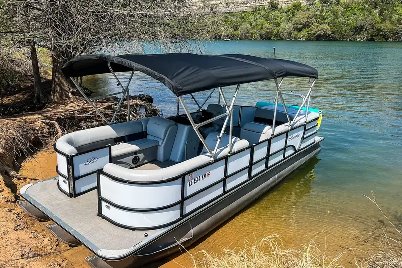 Pontoon boat with a canopy at the shore
